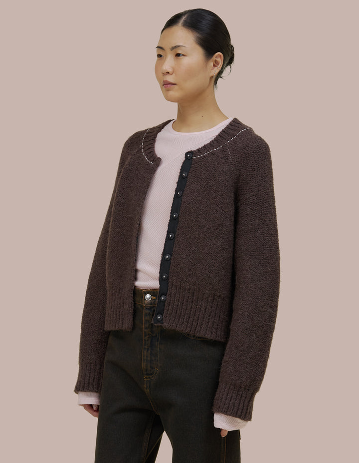 Easy fitting Eckhaus Latta bomber shape jacket in a twisted alpaca/wool boucle yarn. Features an invisible hand sewn metal snap closure and grosgran placket at front. Jacket is linked together with a contrast yarn.