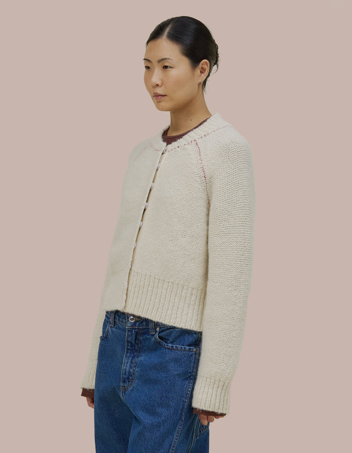 Easy fitting Eckhaus Latta bomber shape jacket in a twisted alpaca/wool boucle yarn. Features an invisible hand sewn metal snap closure and grosgran placket at front. Jacket is linked together with a contrast yarn.