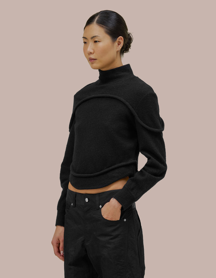 A structured fit Eckhaus Latta turtleneck with subtle tailoring details and bound curvilinear seams creating definition as they move across your body. Made from a boiled wool cotton blend.