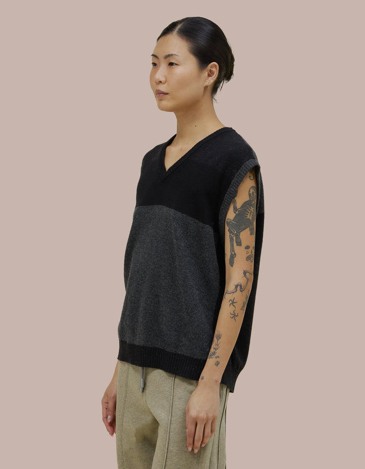 V neck Eckhaus Lata vest with a boxy, oversized fit. Features donegal speckled details throughout the yarn with coloblocking throughout.