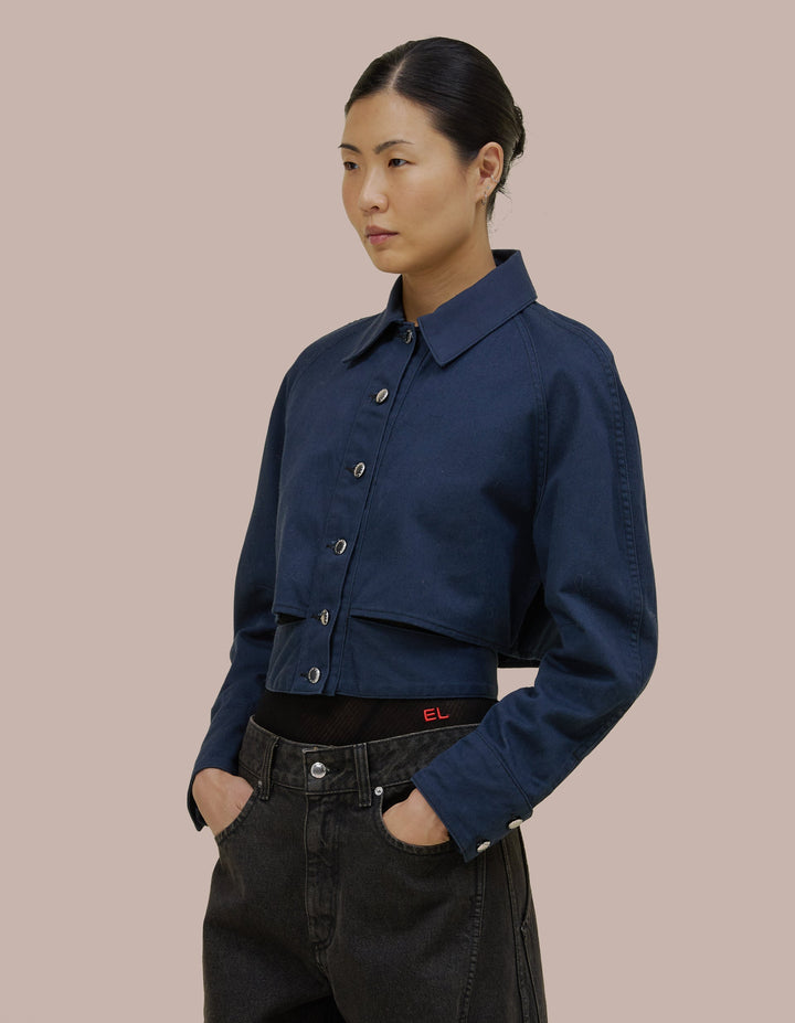 Relaxed, cropped fit in 9oz Japanese denim with raglan sleeves and a contrast collar. Features a button front closure and adjustable waist band.