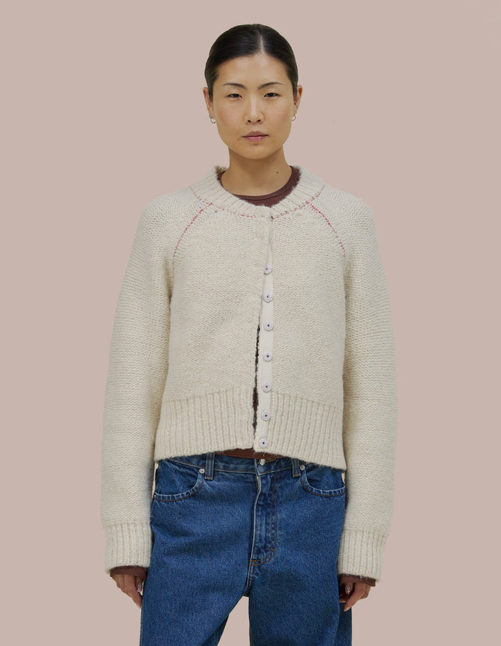 Easy fitting Eckhaus Latta bomber shape jacket in a twisted alpaca/wool boucle yarn. Features an invisible hand sewn metal snap closure and grosgran placket at front. Jacket is linked together with a contrast yarn.