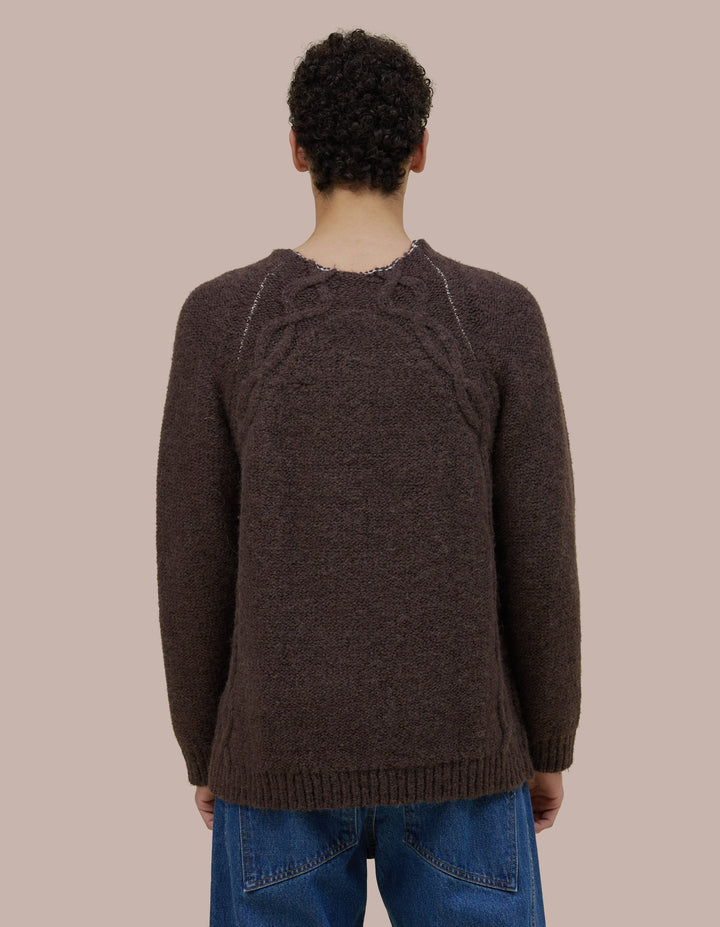 Oversized Eckhaus Latta pullover sweater in a twisted alpaca/wool boucle yarn. Cable details runs all along the body up to funnel neck. Sweater is linked together with a contrast yarn.
