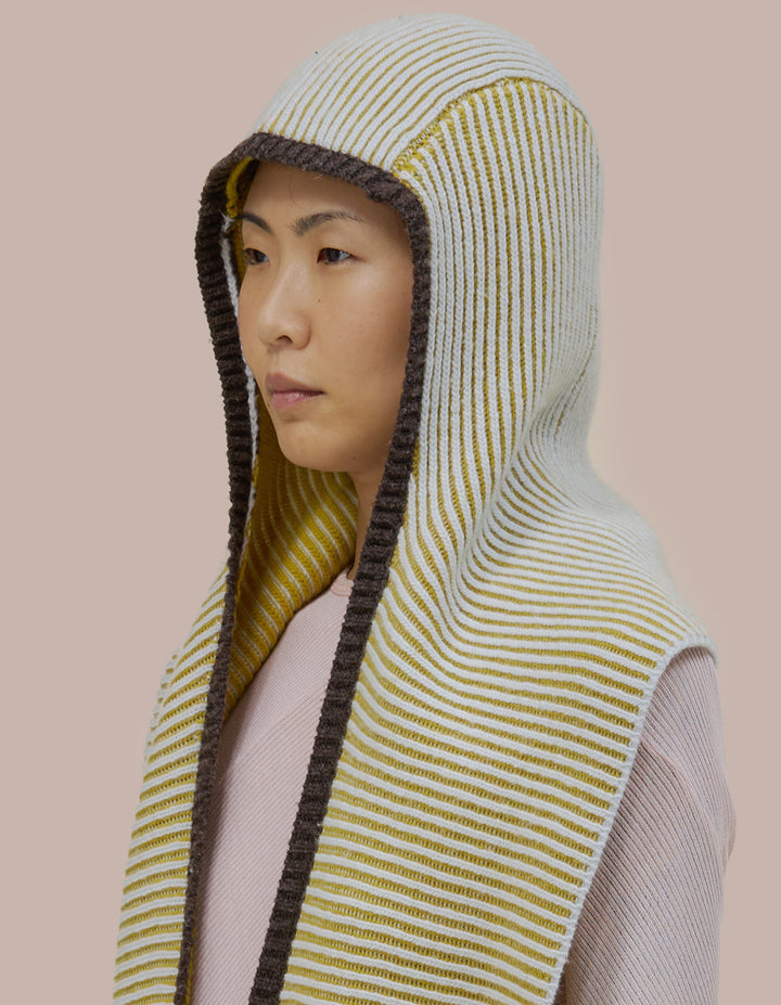 A double knit merino wool scarf combined with a bonnet to frame the face. 