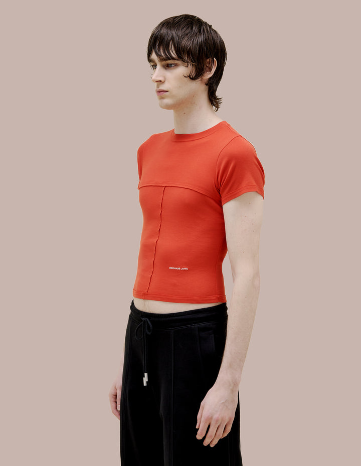 Our classic lapped Eckhaus Lata baby tee in a 1x1 cotton baby rib. Fitted, slightly cropped. Topstitched raw edged seams create form-flattering vertical and horizontal lines across the body. Solid red garment dye finished with an off-white "Eckhaus Latta" logo on the abdomen.