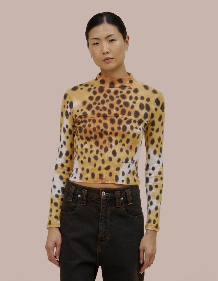 Our classic Eckhaus Latta lapped baby turtleneck in a 1x1 cotton baby rib. Fitted, slightly cropped. Topstitched raw edged seams create form-flattering vertical and horizontal lines across the body. Garment washed in a faux cheetah print using hand-applied dye techniques. Finished with a green "Eckhaus Latta" logo on the abdomen.