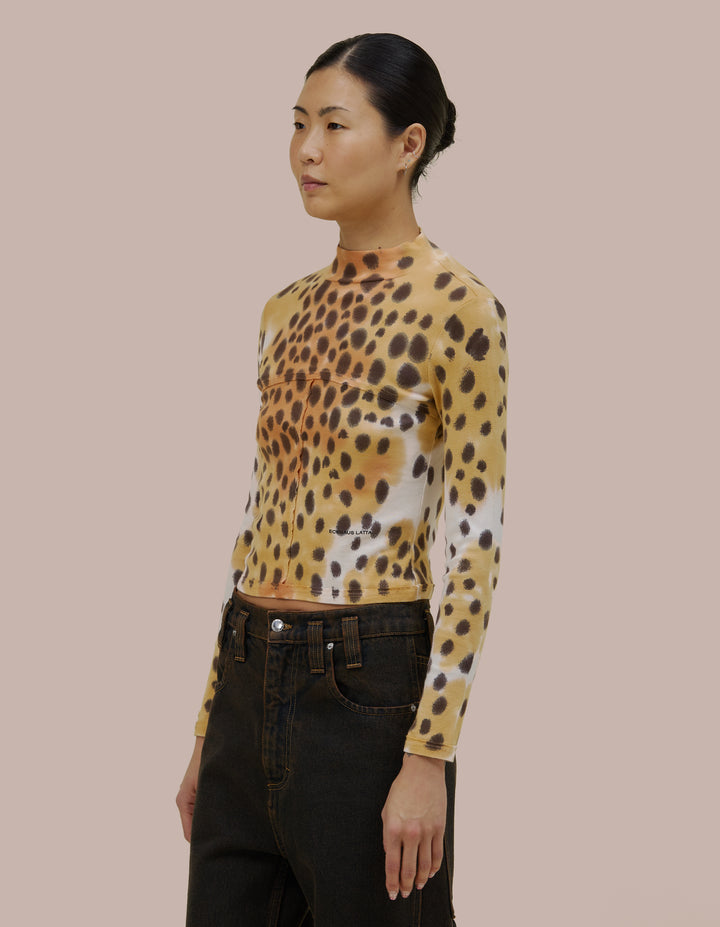 Our classic Eckhaus Latta lapped baby turtleneck in a 1x1 cotton baby rib. Fitted, slightly cropped. Topstitched raw edged seams create form-flattering vertical and horizontal lines across the body. Garment washed in a faux cheetah print using hand-applied dye techniques. Finished with a green "Eckhaus Latta" logo on the abdomen.