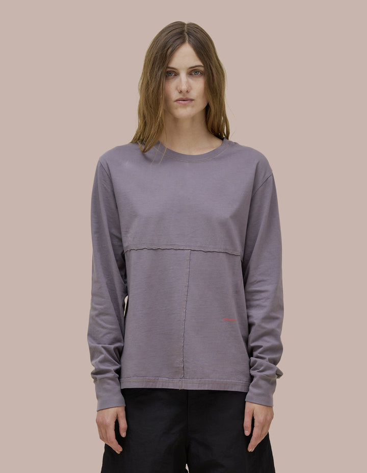 Our classic Eckhaus Latta relaxed-fit lapped long sleeve in Pima cotton jersey with lapped raw-edged seams. Garment dyed in solid gray with olive green contrast topstitching. Finished with an orange "Eckhaus Latta" logo at the abdomen.