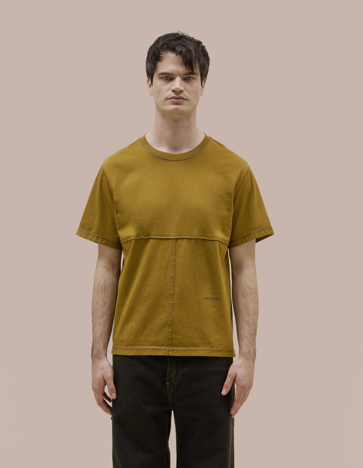 Our classic Eckhaus Latta  relaxed fit tee in Pima cotton jersey with lapped raw-edged seams. Garment dyed in solid olive green with ultramarine blue contrast topstitching. Finished with an ultramarine blue "Eckhaus Latta" logo on the abdomen.