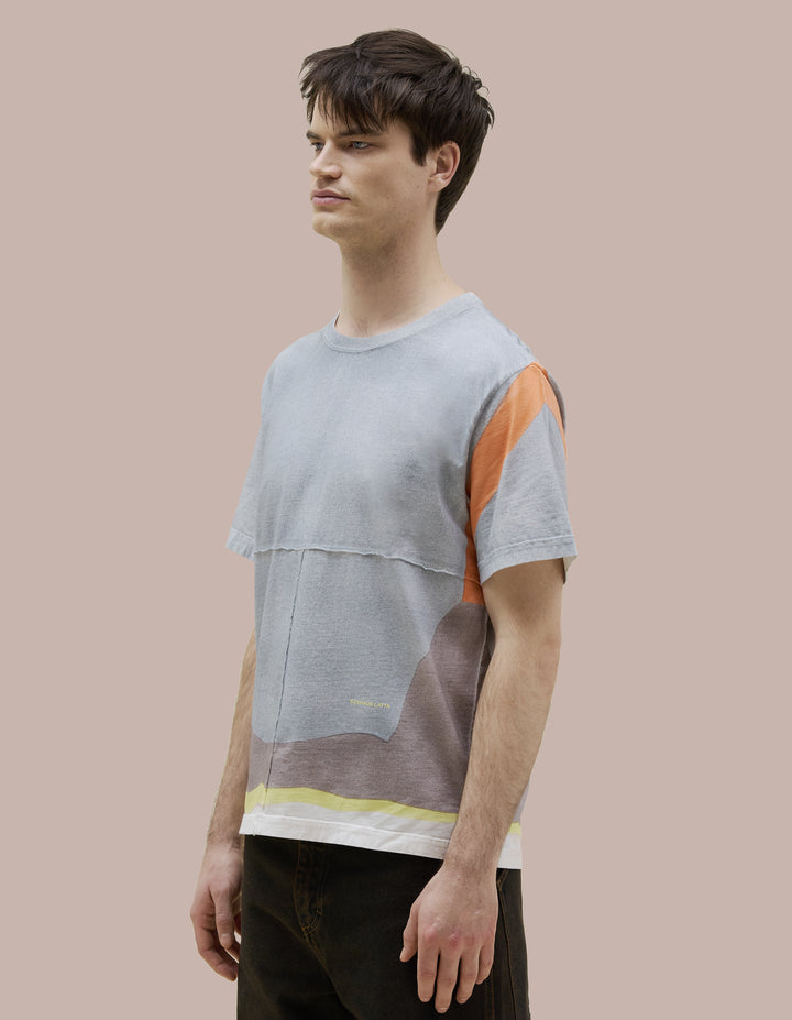 Our classic Eckhaus Latta fit tee in soft Pima cotton jersey with lapped raw-edged seams. Features an all-over speckled spray design, highlighted by vibrant orange shoulder straps and a yellow hem. Finished with a yellow "Eckhaus Latta" logo on the abdomen.