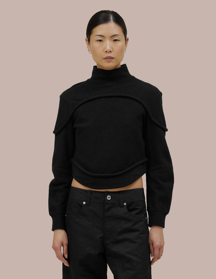 A structured fit Eckhaus Latta turtleneck with subtle tailoring details and bound curvilinear seams creating definition as they move across your body. Made from a boiled wool cotton blend.