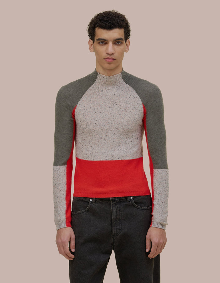 Slim fitting femme  Eckhaus Latta turtleneck with a funnel neckline and raglan sleeves. Features donegal speckled details throughout the yarn with coloblocking throughout. 